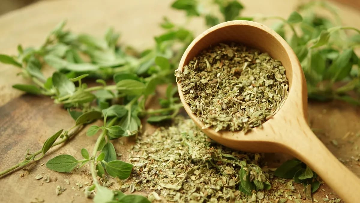 Oregano getrocknet und gerebelt auf einem Holztisch.